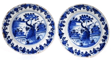 A pair of late 18thC Delft blue and white plates, chinoiserie decorated with stylised trees, 26cm diameter.