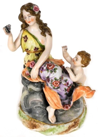 A 19thC Continental porcelain figure group of lady and putto, polychrome decorated in yellow and peach, on a shaped gilt line base, MV and crown mark, 13cm high.