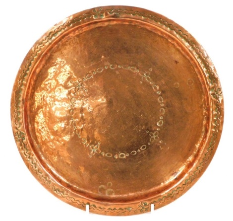 A late 19thC Arts & Crafts copper plate, with a floral pattern and geometric border, unsigned, 27cm diameter.