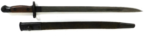 An early 20thC Remington bayonet, dated 1907, with part leather scabbard, wooden grip, 58cm long.