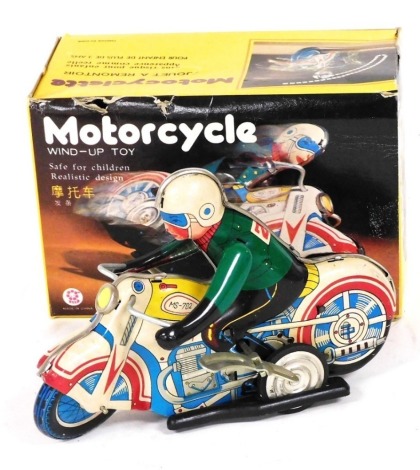 A Chinese wind up tin plate motorcycle toy, complete with box.