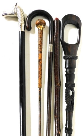 Various walking sticks, horse headed example with tapering ebonised stem, 21cm long, walking cane with silver collar, tribal style staff, etc. (a quantity)