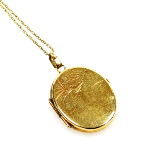 A 9ct gold locket, with engraved decoration and chain, 2.9g all in.