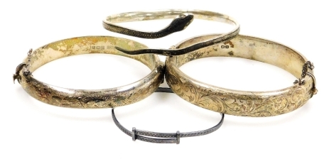 Two silver hollow bangles, a silver coloured metal bangle and child's bangle. (4)