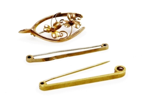 A yellow metal horseshoe and flower brooch, and two yellow metal stick pins, each with base metal pins, 6.7g all in.