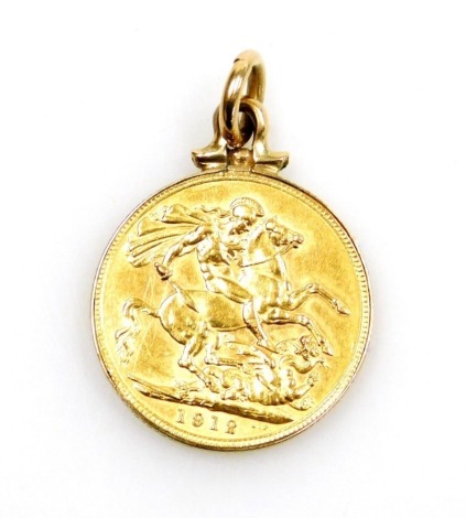 A George V 1912 gold half sovereign, in casing, yellow metal mount, unmarked, 7.2g all in.