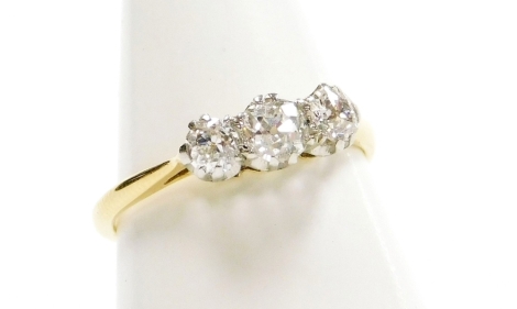 A diamond three stone ring, brilliant cut in a claw setting, white and yellow metal, stamped 18ct plat, approx 0.5cts, size K½, 2.4g all in.