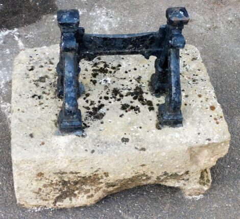 A late 19thC cast iron boot scraper, mounted on a stone plinth, 43cm wide.