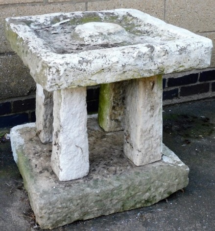 A rough hewn stone bird bath, of pagoda form with square top and base, later painted white, 63cm high, 62cm wide.