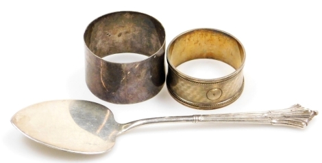 A group of small silver, comprising two silver napkin rings, Birmingham 1942, the other hallmarks rubbed, and a Victorian silver Albany pattern cake slice, London 1891, 17cm long, 2¾oz.