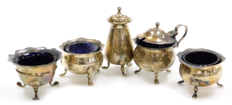 An Edward VII silver part cruet, comprising two open salts with blue glass liners, mustard pot with blue glass liner and salt, Sheffield 1906 and 1907 and a further open salt with blue glass liner, London 1898, weighable silver 6oz.