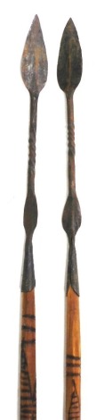 Two African spears, with double leaf shaped and spiral twist blades, and carved wooden shafts, 140cm high.