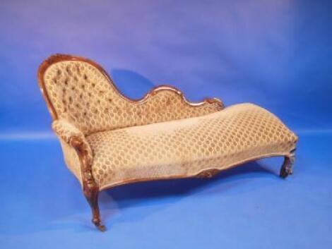 A Mid Victorian upholstered carved walnut chaise longue on cabriole legs and castors