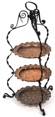 A late 19th/early 20thC Arts and Crafts wrought iron and copper three tier cake stand, with handle, 61cm high.