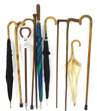 Walking sticks and umbrellas, parasols and a walking stick, too include an example with a silver collar. (a quantity)