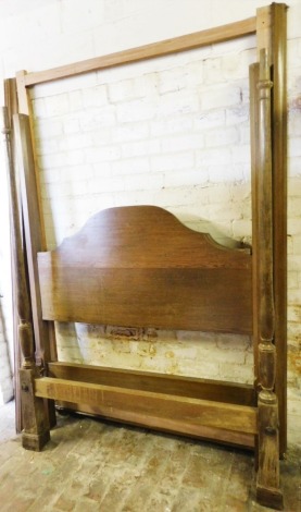 An oak double half tester bed, with iron side rails.