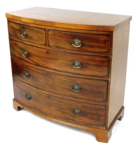 A George III mahogany bow front chest of drawers, with two short over three long drawers, each with oval brass drop handles, raised on bracket feet, 101cm high, 107cm wide, 51cm deep.