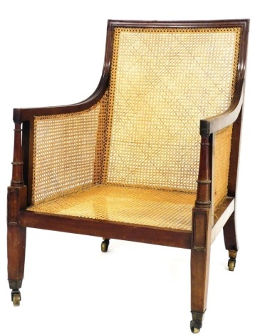 A 19thC mahogany bergere armchair, with moulded frame, caned back, sides and seat, on square tapering legs with brass castors.