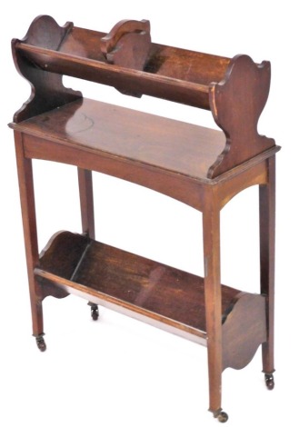 An Edwardian mahogany book trough, the top with an adjustable slide, the base with a moulded edge and further canted recess for books, on castors, 78cm high, 56cm wide, 23cm deep.