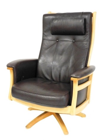 An Ercol light elm and brown leather upholstered adjustable swivel armchair, with X shaped support.