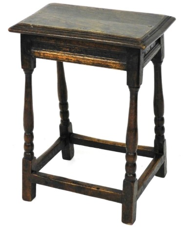 An oak joint stool, the rectangular top with a moulded edge, above a shallow carved frieze, on turned supports, 59cm high, 43cm wide, 26cm deep.