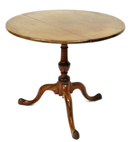 A George III mahogany tilt top supper table, the circular top raised over a baluster turned column, above three cabriole legs, 71cm high, 84cm diameter.