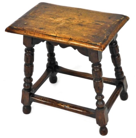 A Jacobean style oak joint stool, with plain rectangular top raised on baluster supports, joined by plain block stretchers, 48cm high, 45cm wide, 29cm deep.