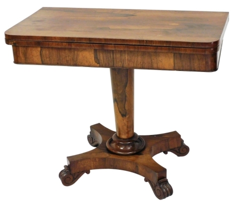 A William IV rosewood card table, the rectangular fold over top with rounded corners enclosing a baize lined interior, on a cylindrical tapering column and concave platform, with scroll carved feet, 74cm high, 91cm wide, 45cm deep.