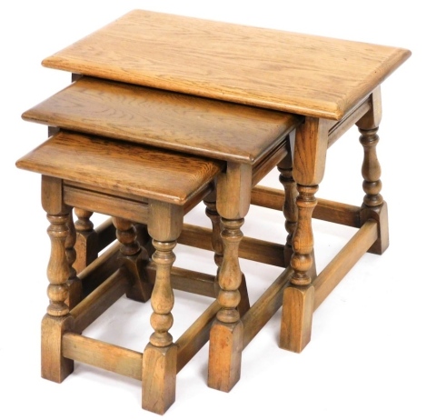 A nest of three Old Charm oak tables, the largest 45cm high.