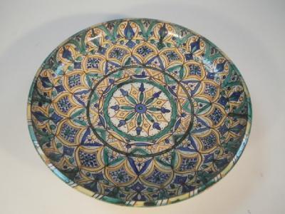 A large faience circular pottery dish decorated with Iznik decoration