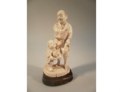 A late Meiji period Japanese Okimono figure of a man with his son and toy horse