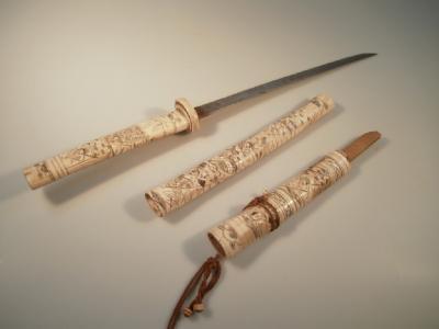 A 19thC Japanese short sword with carved and worked ivory handle and scabbard