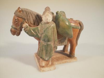 A Chinese Ming dynasty horse and groom pottery figure in green and amber glaze