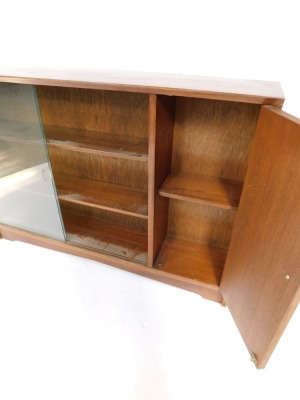 A mid century mahogany low bookcase, with two sliding glass doors, above three shelves with single cupboard door, 85cm high, 121cm wide, 24cm deep. - 3