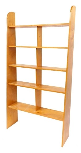 A hardwood sectional bookshelf, with central split panel above five shelves, on shaped end supports, 202cm high, 108cm wide, 24cm deep.