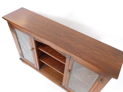 A pair of Old Charm oak cabinets, with two astragal glazed doors and central bookshelf section, on bracket feet, 83cm high, 121cm wide, 28cm deep. - 2