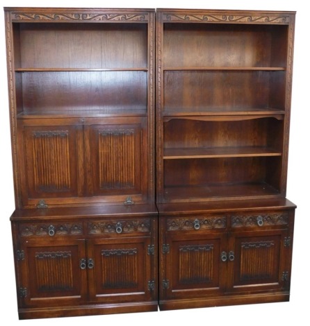 Two oak Old Charm cabinets, each with bookcase top, with two single drawers and two cupboard door base, one with writing desk fall flap section, 196cm high, 91cm wide, 42cm deep.