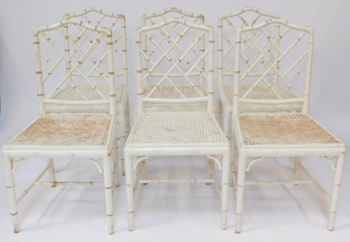 A set of six distressed cream painted dining chairs, each with simulated bamboo supports, white painted with cane seats.
