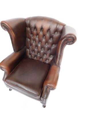 A brown leather Thomas Llyod Chesterfield wingback armchair, with button and stud detailing on mahogany out splayed legs, 102cm high, 76cm wide, 65cm deep. - 2