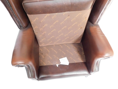 A brown leather Thomas Llyod Chesterfield wingback armchair, with button and stud detailing on mahogany out splayed legs, 102cm high, 76cm wide, 65cm deep. - 4