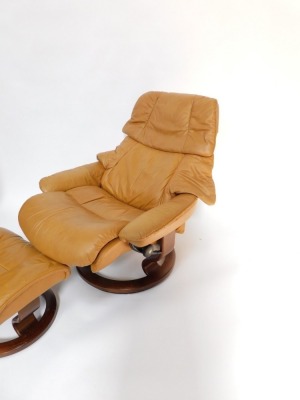 A Stressless tan leather swivel armchair and footsool. - 3