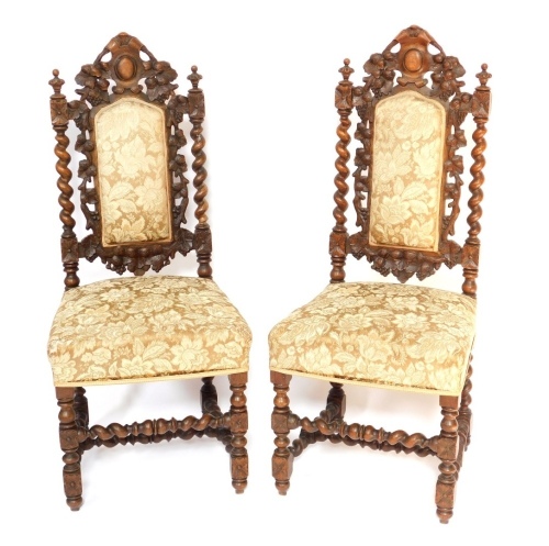 A pair of late 19thC carved oak side chairs, each with gold upholstered back and seat, with barley twist column supports, leaf vine detailing, 115cm high, 48cm wide, 43cm deep.