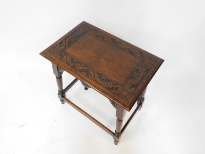 An early 20thC carved oak side table, the rectangular top of star and sun detailing, on a rectangular framed base, 64cm high, 61cm wide, 40cm deep. - 2