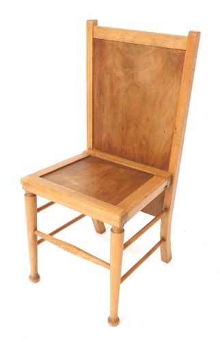 An Arts & Crafts style light beech chair/trouser press, with solid seat and back, raised on turned legs, united by spindles, 89cm high, 40cm wide, 38cm deep.