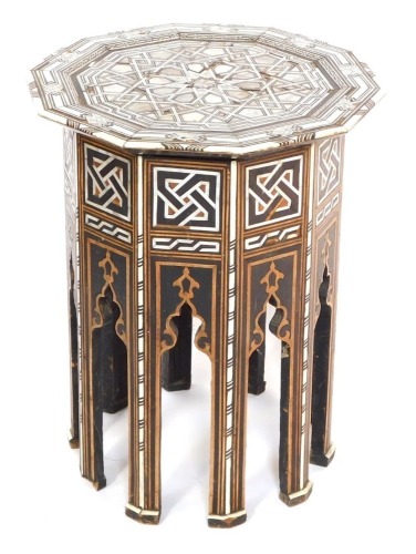 An early 20thC Damascus type mother of pearl inlaid table, the top raised on panelled sides, with mihrabs, on tapering straight legs, possibly retailed by Liberty, 51cm high, 41cm wide. (AF)