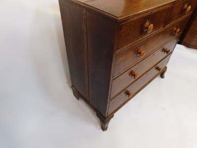 A George III oak chest of two short over three long graduated drawers, raised on outswept feet, 103cm high, 109cm wide, 53.5cm deep. - 3