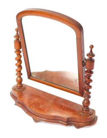 A Victorian mahogany swing framed toilet mirror, raised on turned and spiral twist columns, over a serpentine base, raised on three leaf carved feet, 66cm high, 64cm wide.