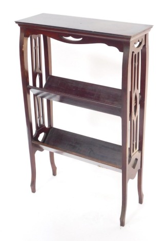 An Edwardian mahogany book trough, with fretwork sides, having two troughs, raised on slender cabriole legs, 59cm high, 57cm wide, 21cm deep.