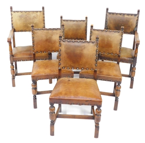 A set of six Victorian Carolean style oak dining chairs, each with a studded leather back and seat, comprising two carvers and four single chairs.