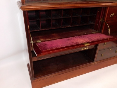 A Victorian mahogany office library bookcase, the carved outswept pediment over an open case of two adjustable shelves, the lower section with a drop front opening to reveal eight recesses, above a further bookcase flanked to the right by four drawers, ra - 3